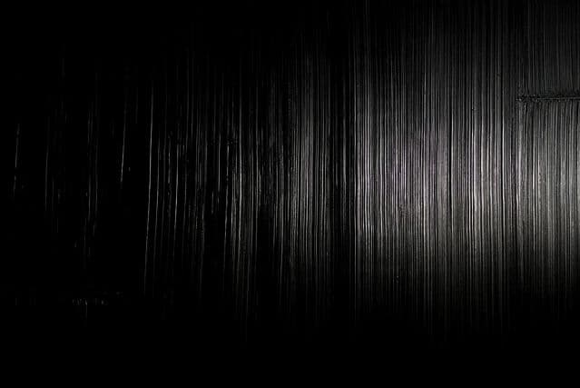 Black painting in raking light, vertical striations